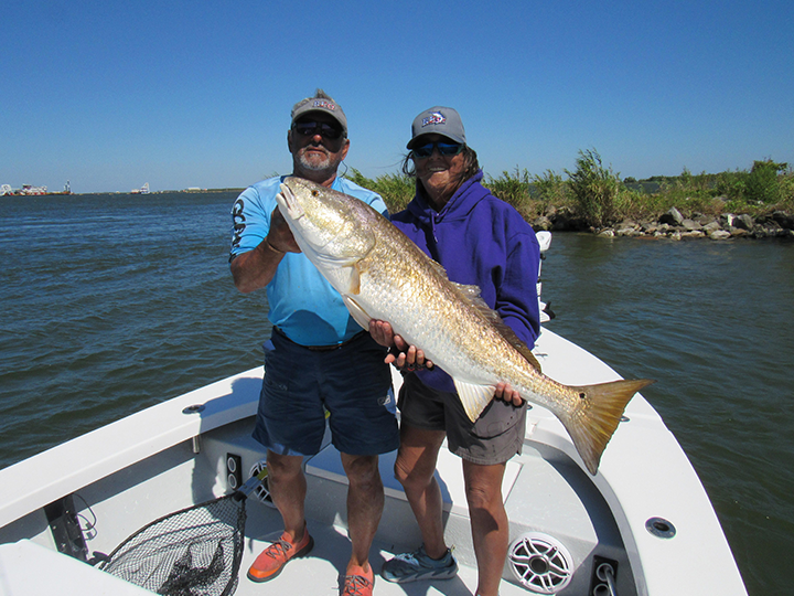 two veterans on boat from fishing trip with large fish